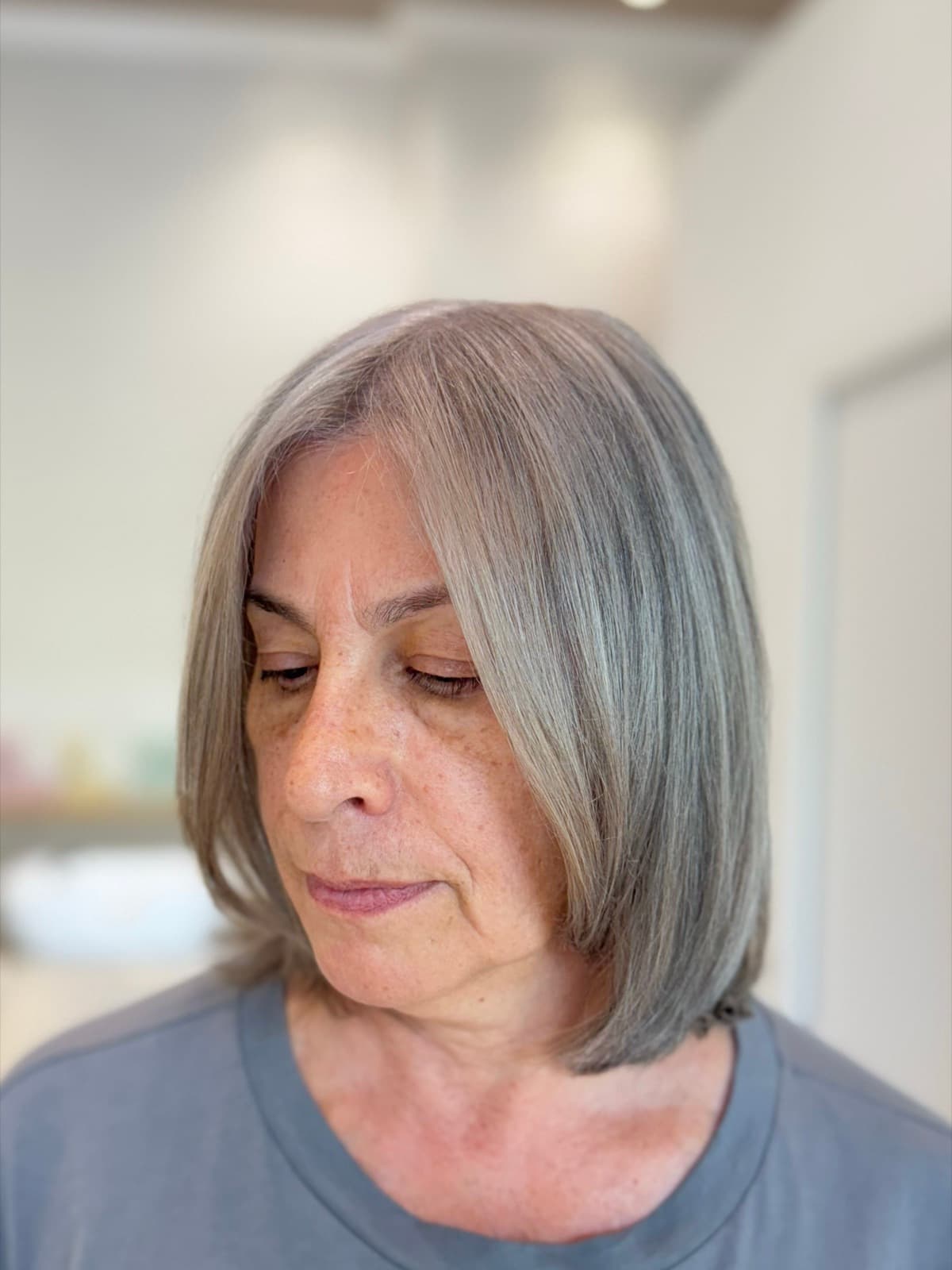 Cheveux blancs fondus après le Grey Blending, nuances argentées harmonisées sur un carré net