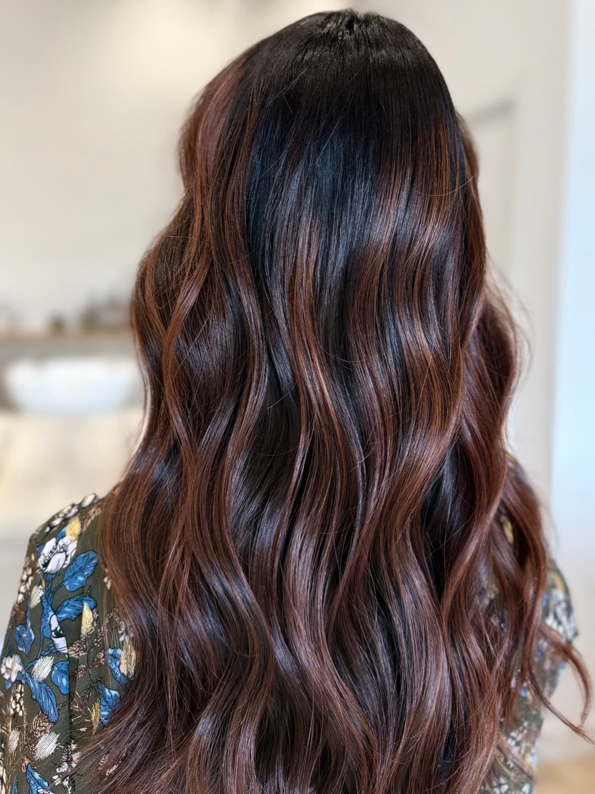 Balayage acajou aux reflets cuivrés sur cheveux longs ondulés