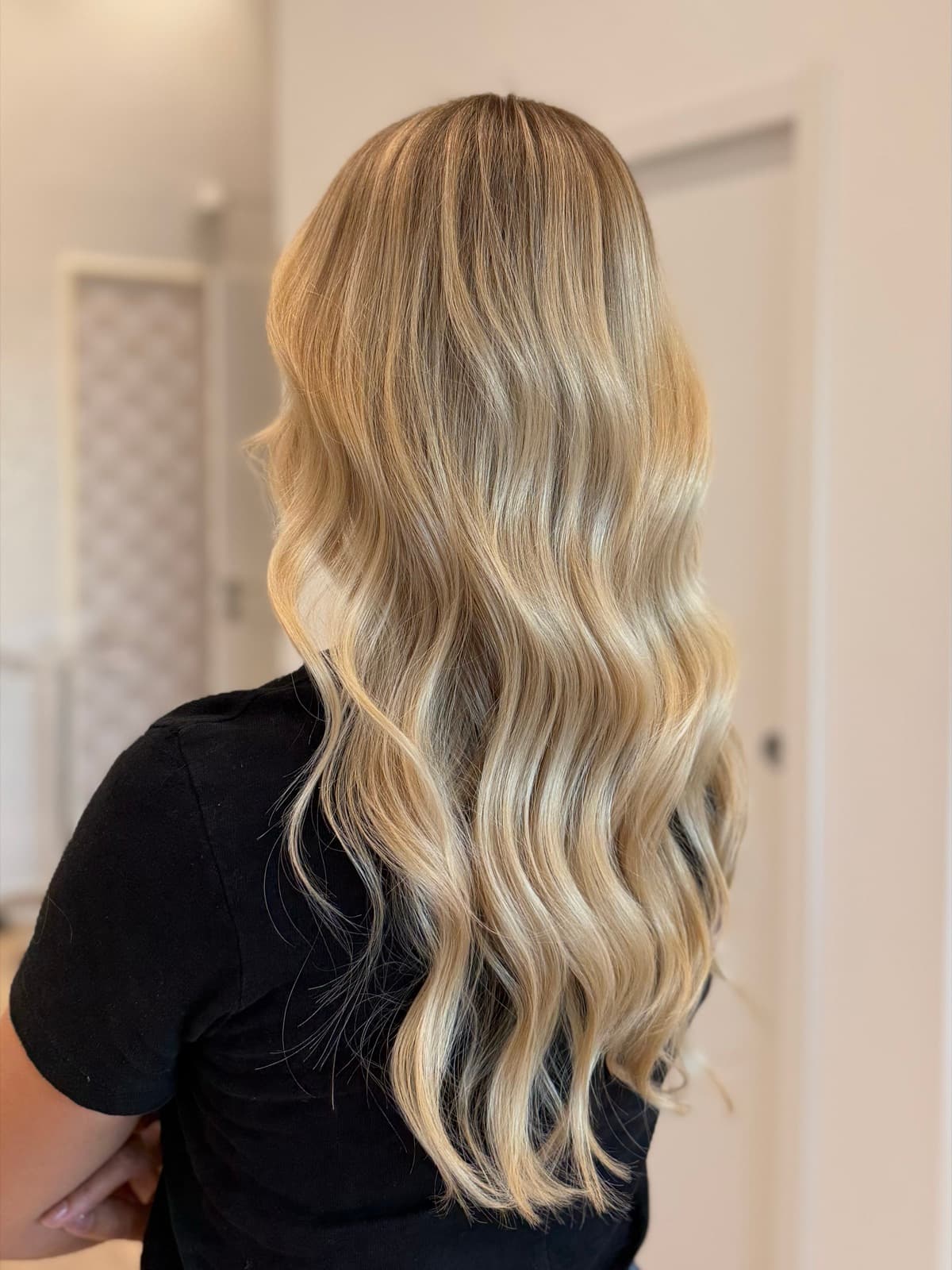 Balayage blond doré sur cheveux longs ondulés