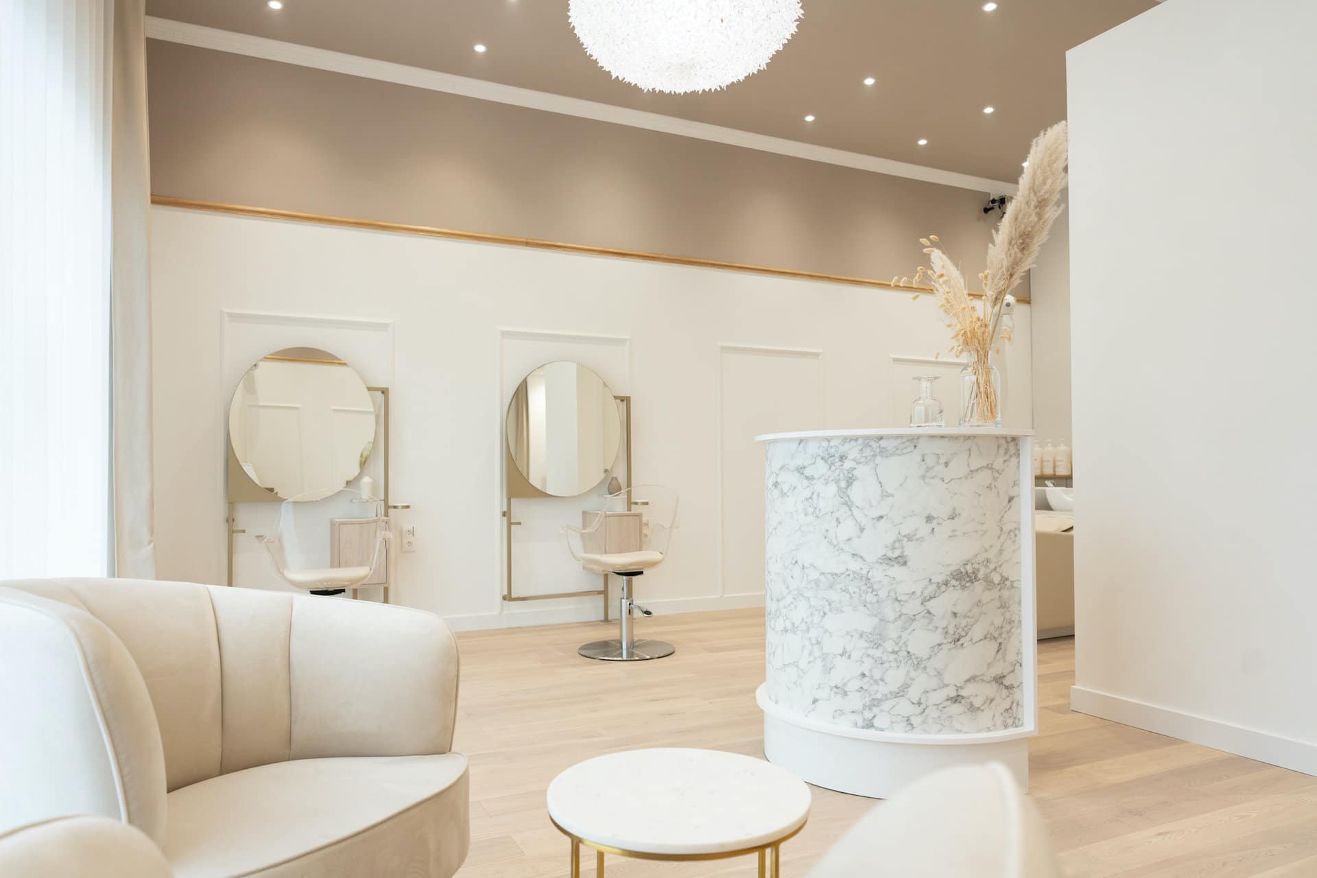 Vue du salon : miroirs, fauteuils et comptoir de marbre